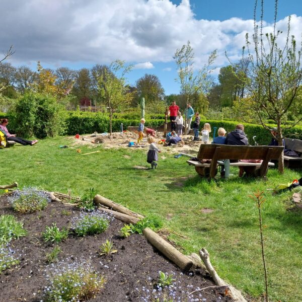 Kinderen aan het spelen in de zandbak in de natuurspeeltuin